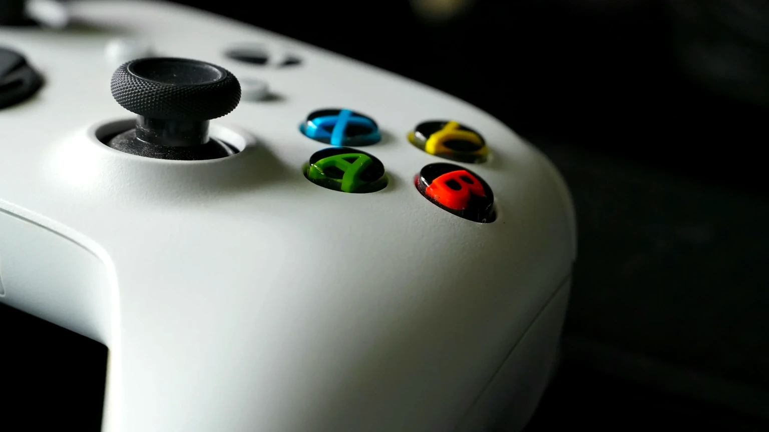 A close-up of a white Xbox controller with colorful buttons, representing gaming identity by Quick Counter Tools.