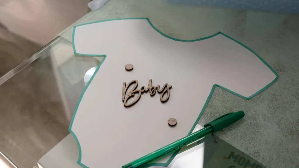 A creative baby naming activity featuring a onesie cutout and a pen to help parents brainstorm and agree on a baby name parents can't agree on a baby name