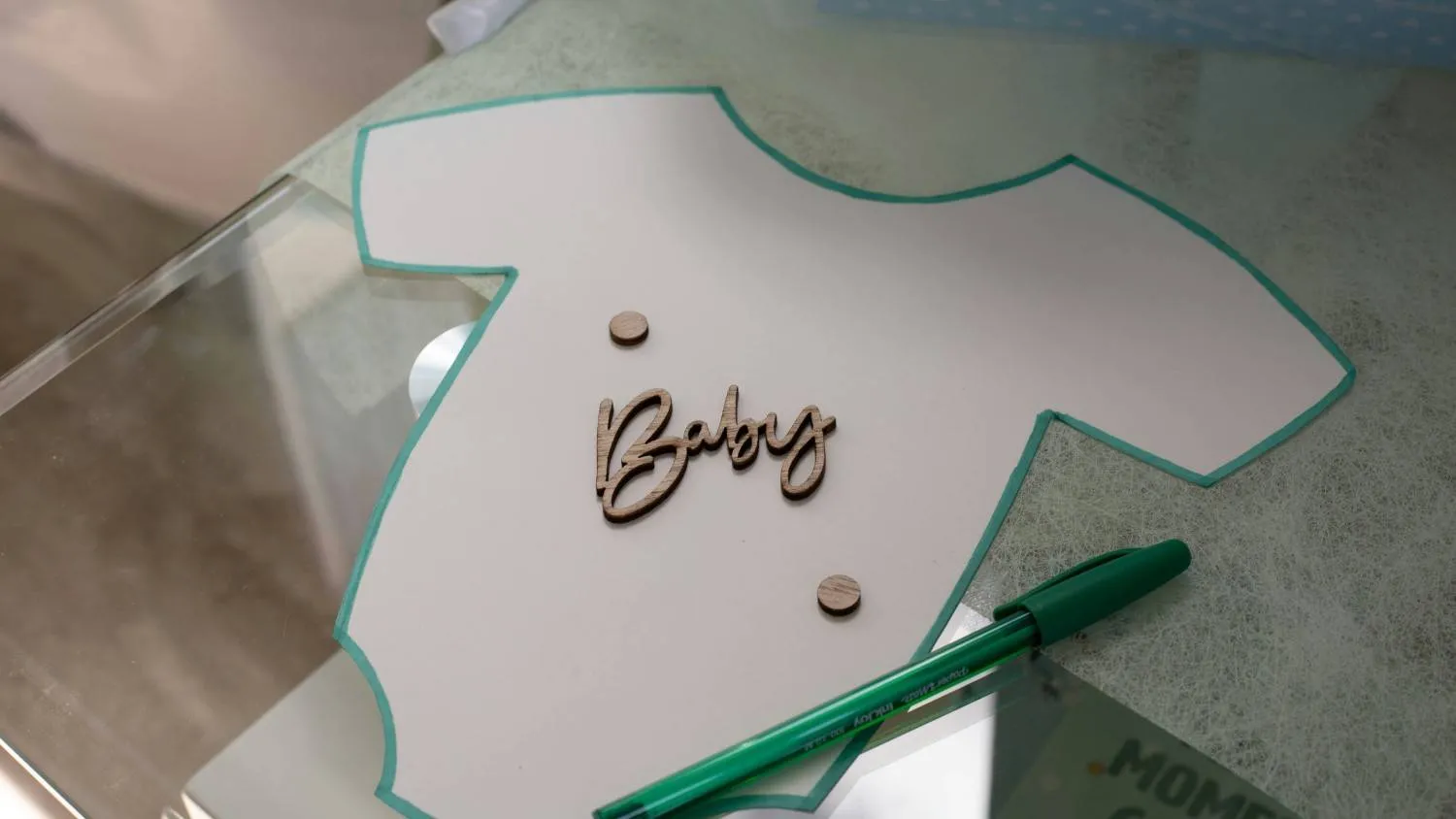 A creative baby naming activity featuring a onesie cutout and a pen to help parents brainstorm and agree on a baby name parents can't agree on a baby name